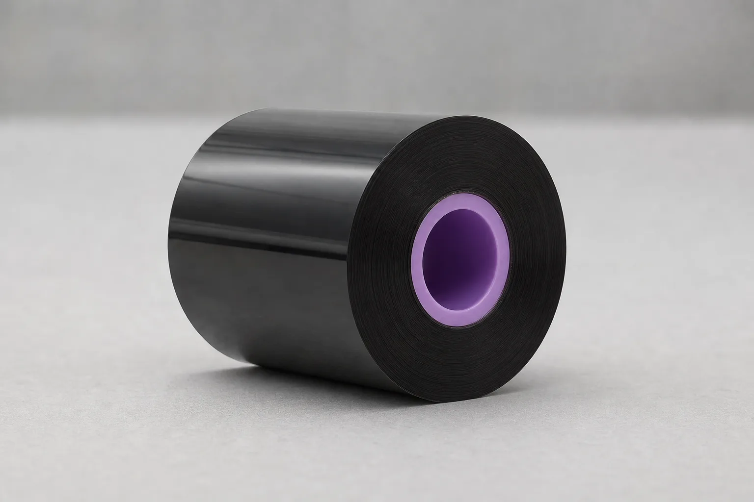 Close view of a black TTO ribbon roll showing its core opening and wound-film edge.